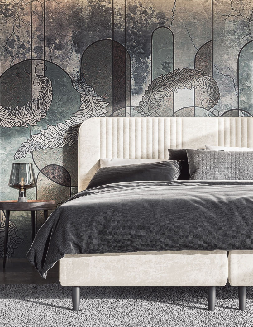 Beżowe łóżko kontynentalne z pionowymi przeszyciami na zagłówku. W tle zdobna tapeta, całość utrzymana w ciemnych kolorach.