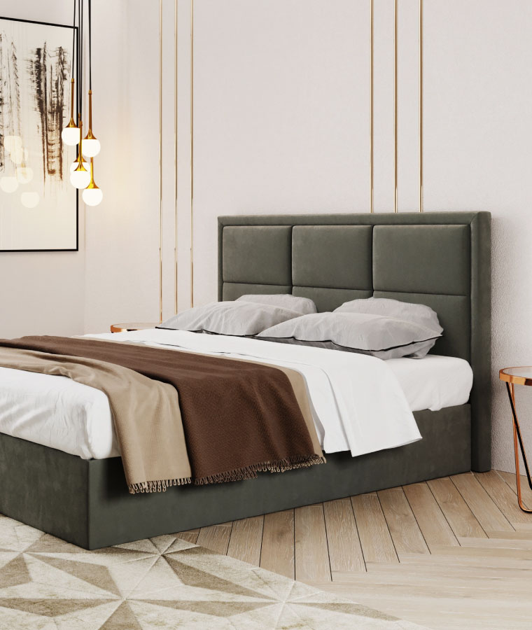 Szare łóżko kontynentalne ze zdobionym zagłówkiem, w tle plakat na ścianie oraz złote lampy zwisające z sufitu.