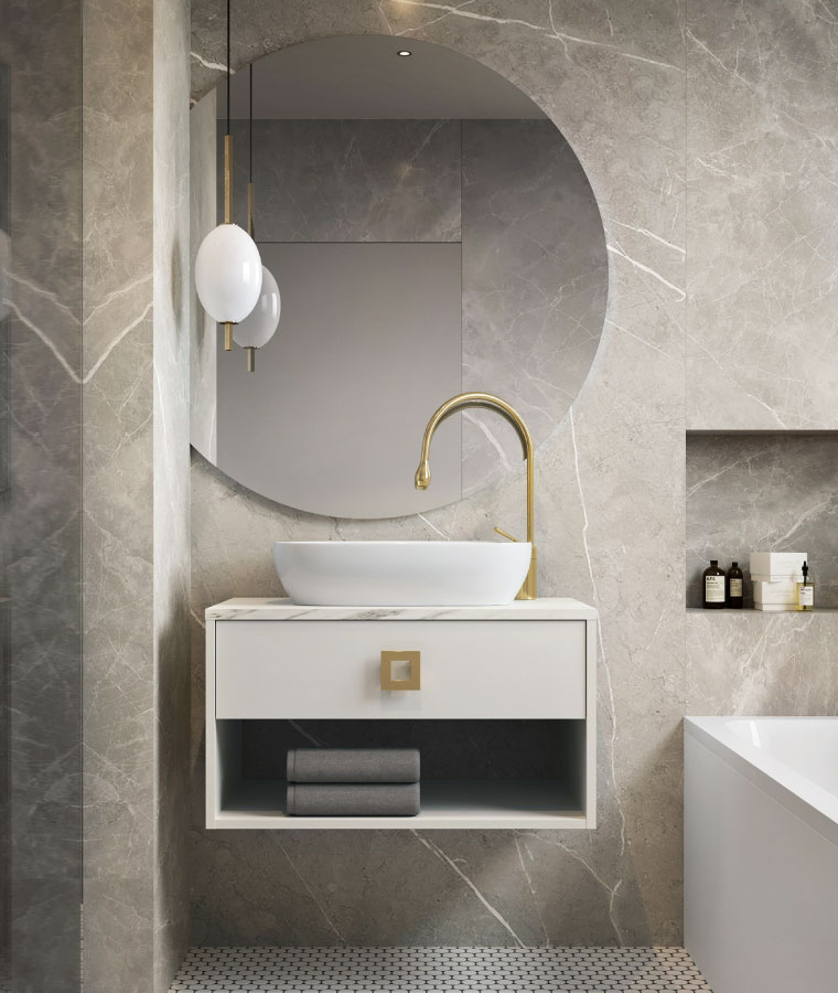 Łazienka w stylu modern classic z marmurowymi płytkami i beżową szafką umywalkową z czarnym blatem i złotymi uchwytami przy szufladach.