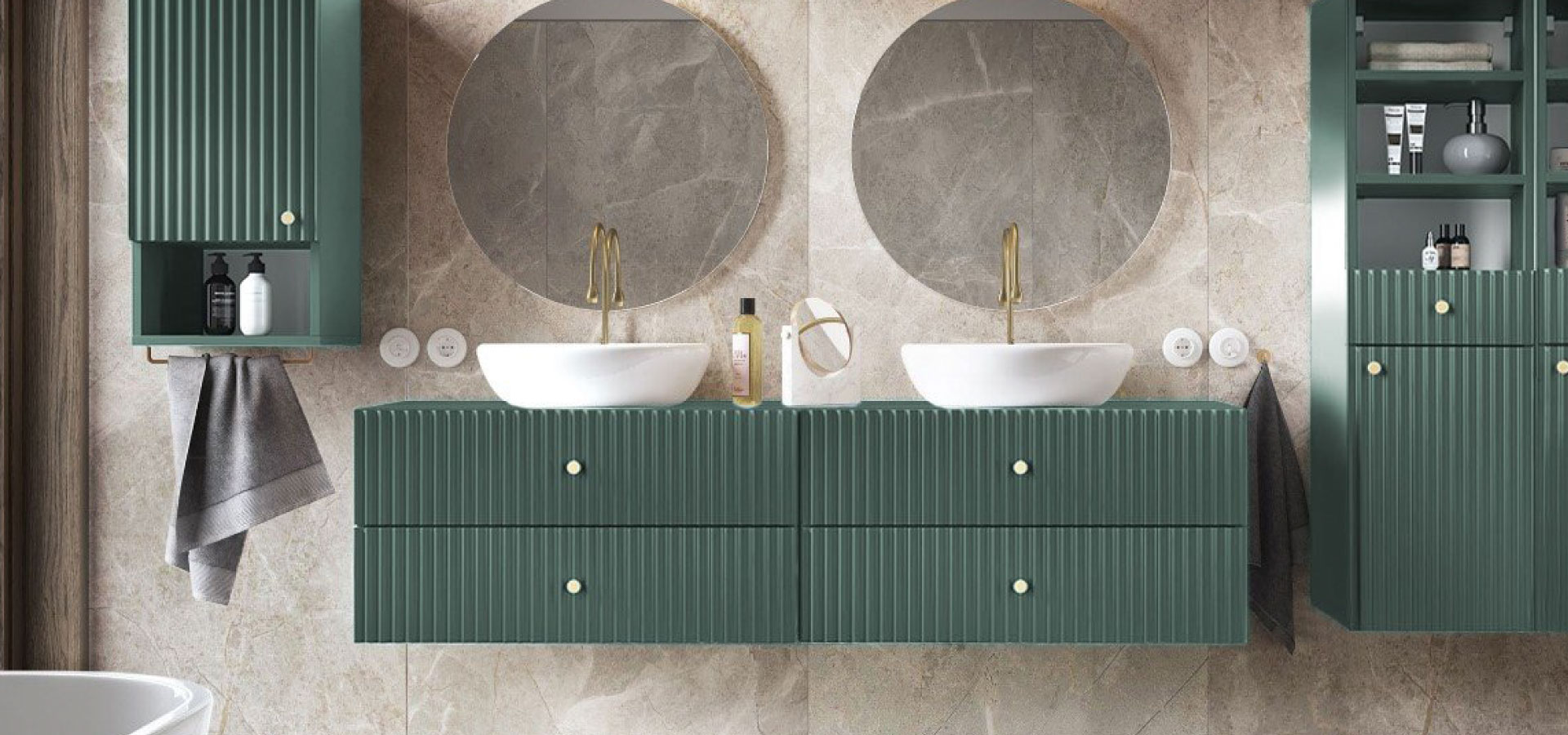 Nowoczesna łazienka utrzymana w beżu i zieleni, z wiszącymi szafkami w kolorze szałwiowym. Nad umywalkami dwa okrągłe lustra i złota armatura.