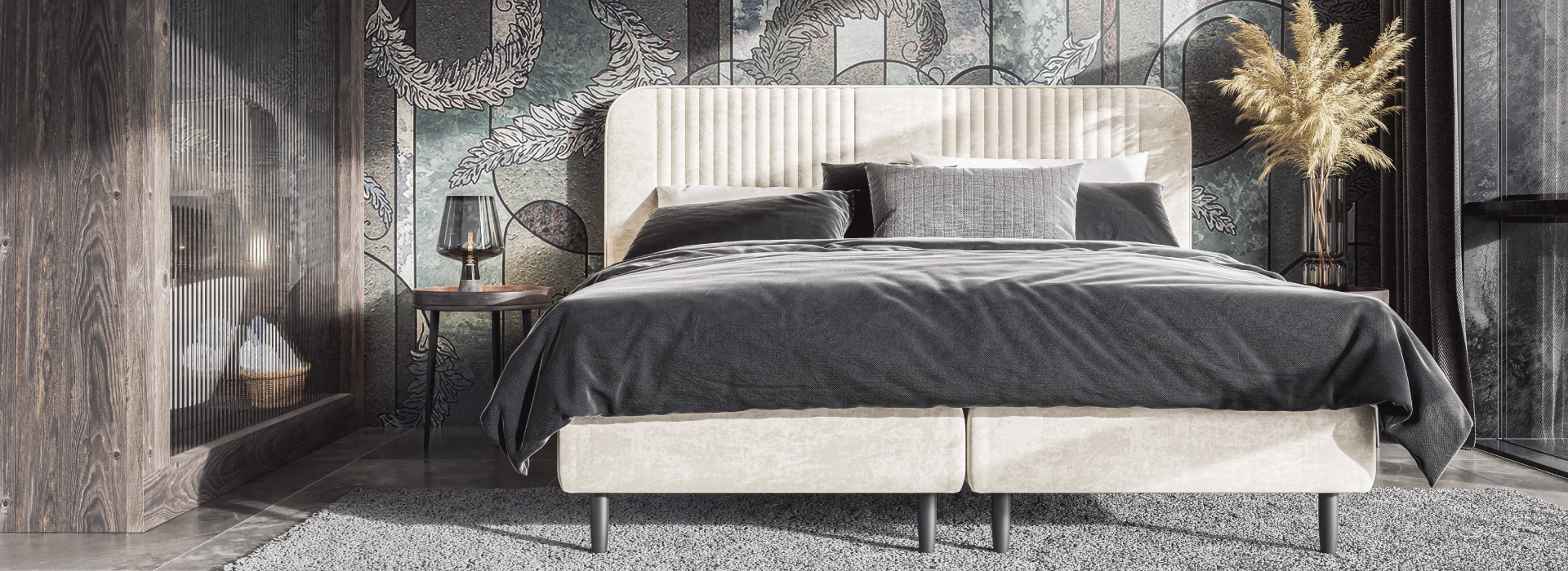 Jasnobeżowe łóżko z dekoracyjnymi przeszyciami na całości, ustawione w eleganckim pomieszczeniu w granatowe i złote barwy. Po obu stronach łóżka złote stoliki.