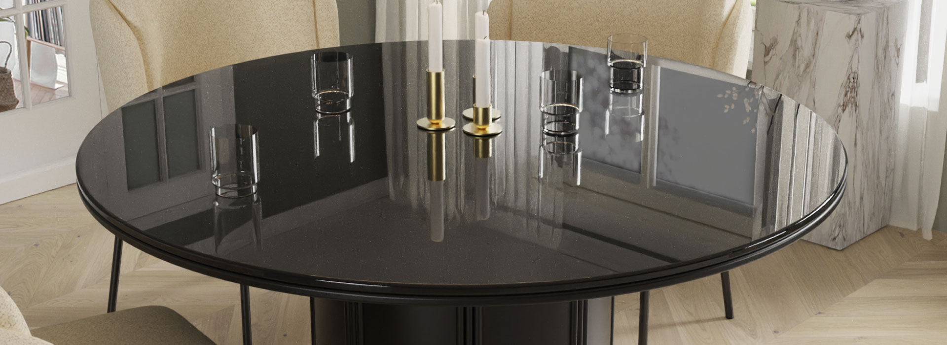 Czarny stół na jednej nodze ze szklanym blatem, na którym stoją szklanki oraz trzy złote świeczniki z białymi świecami.